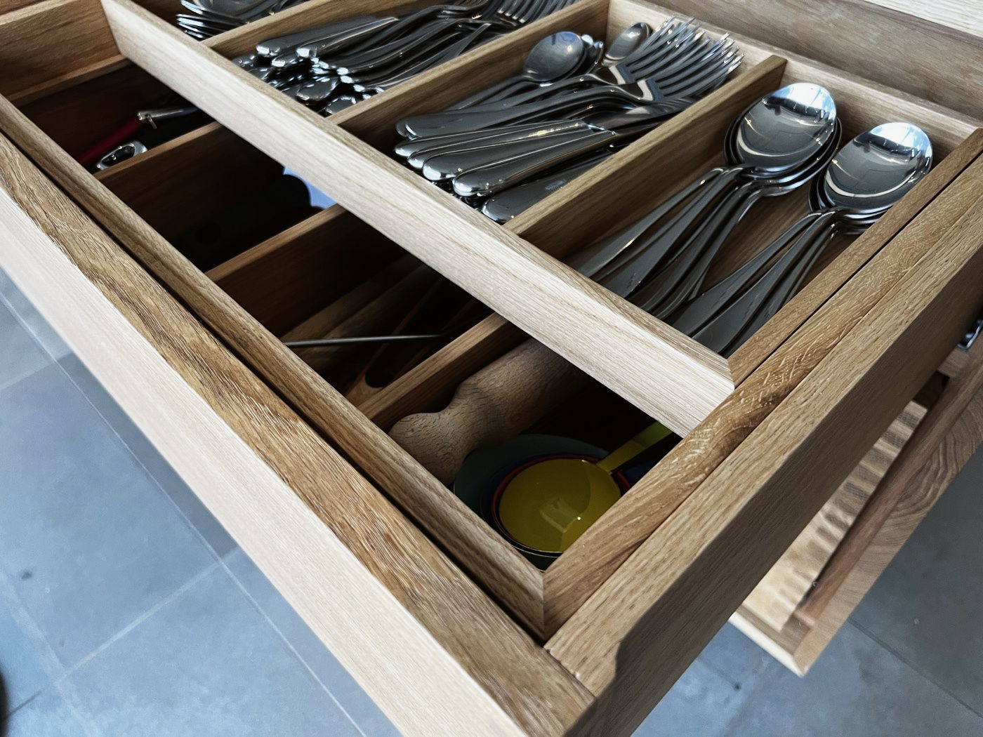 A cutlery drawer with dividers in a bespoke kitchen