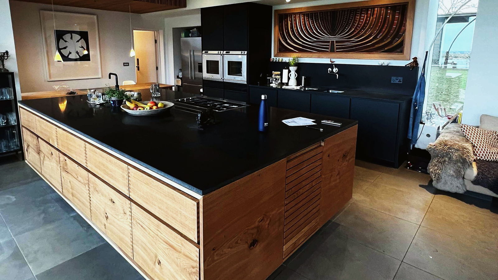 A bright fitted kitchen with a range cooker, painted cabinetry and a kitchen island in an Essex house