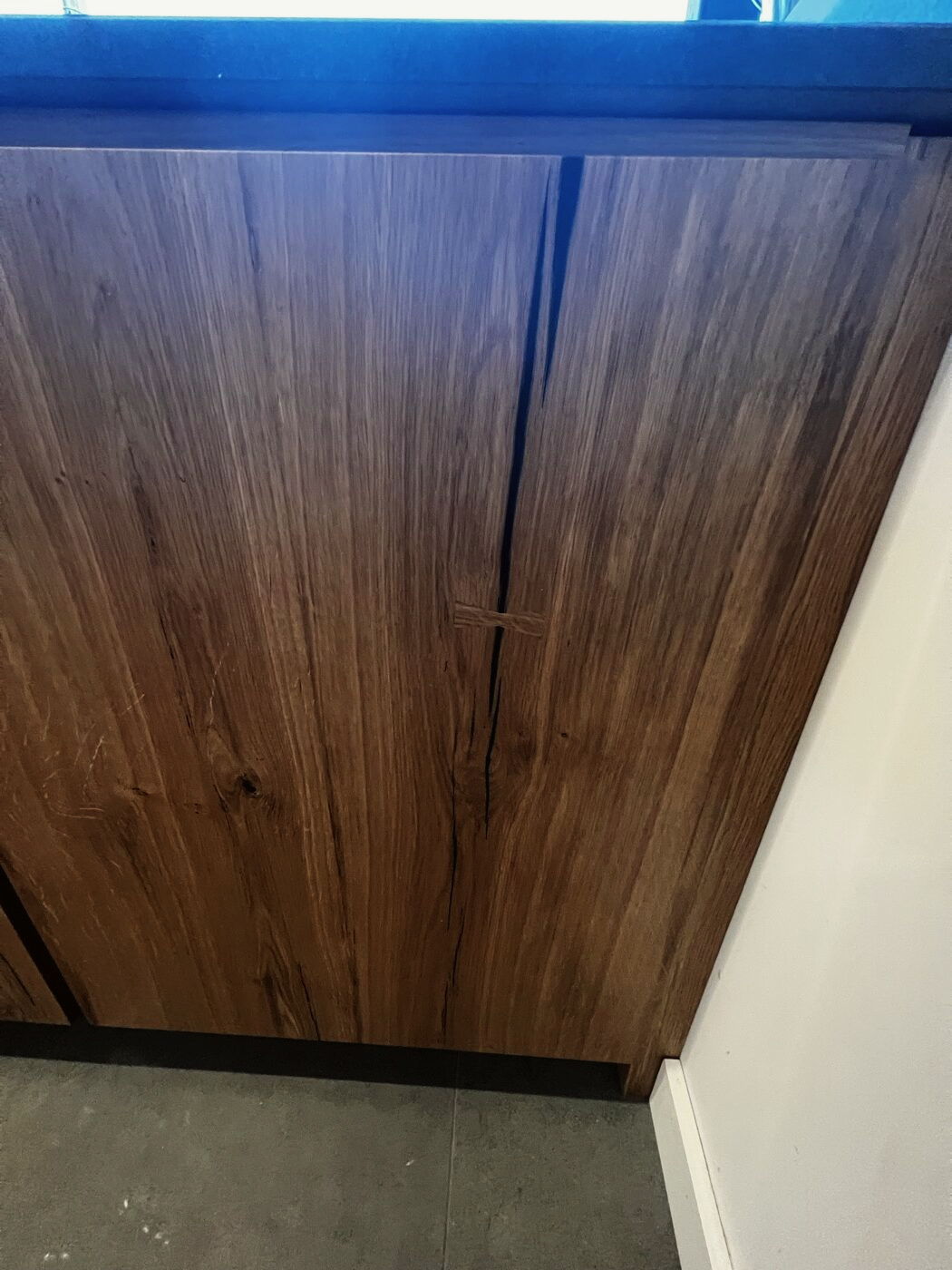 A walnut corner cabinet in a painted kitchen