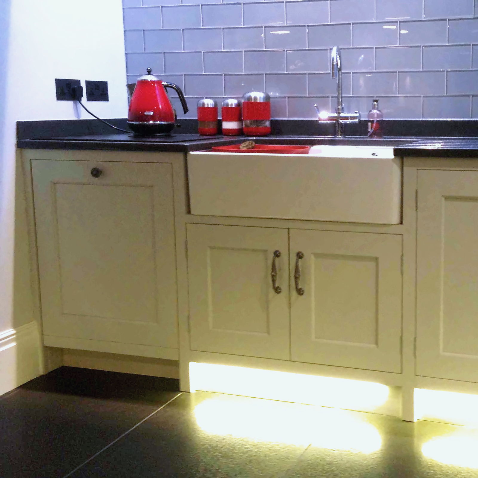 Painted Shaker kitchen cabinetry with an apron-front sink and dark worktop