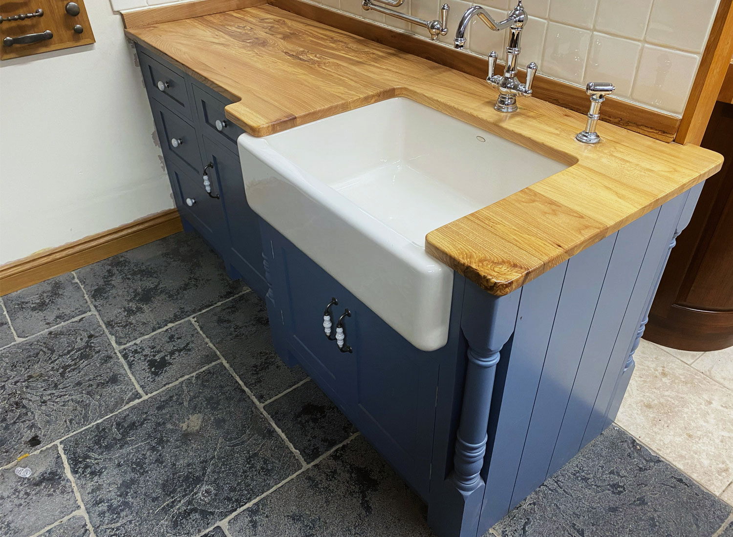 A painted base run under a solid timber top, with a butler sink
