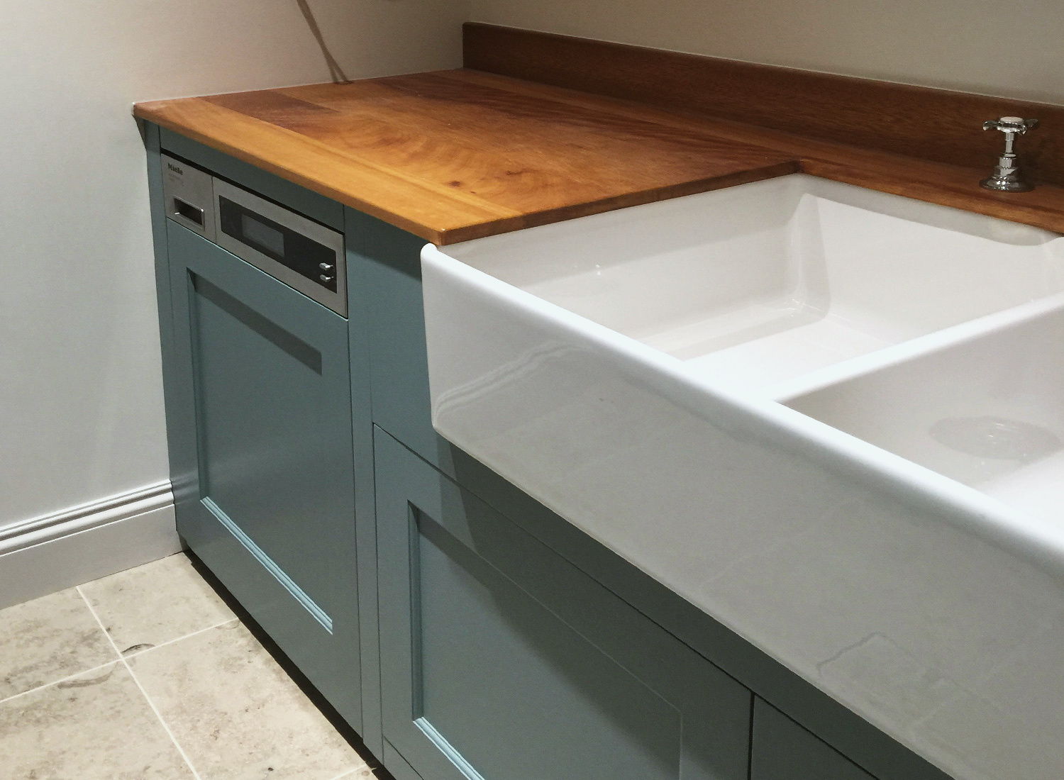 A sprayed utility unit with a stone top and a butler sink