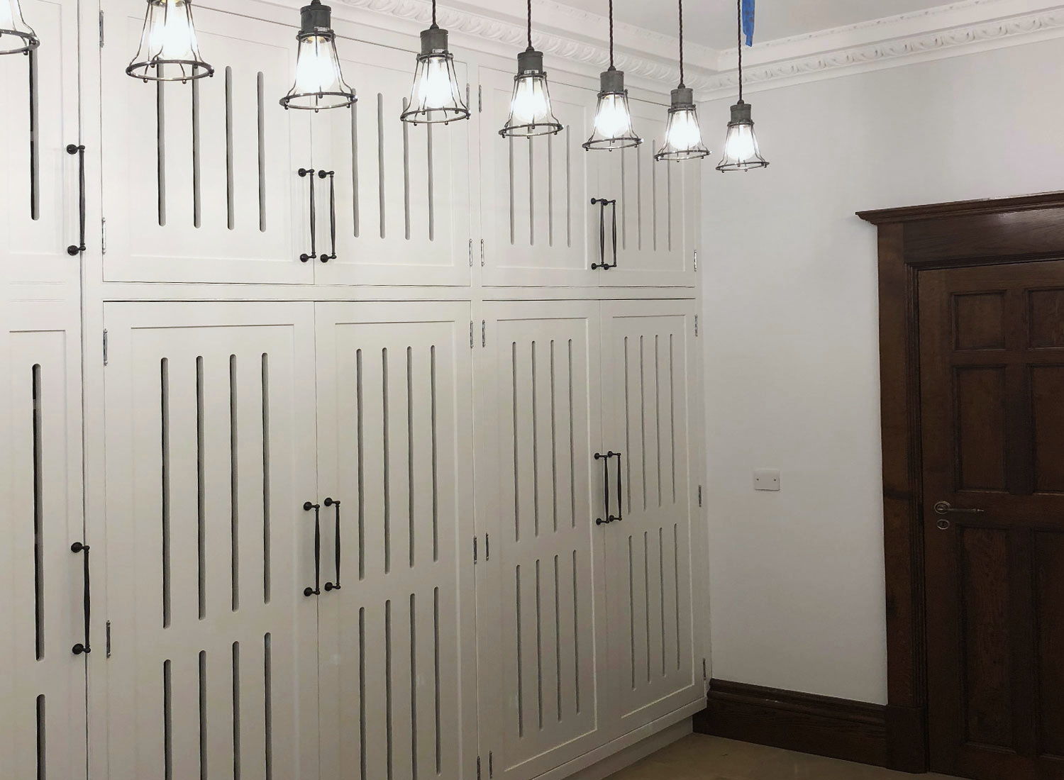 Full-height painted cupboards with slatted doors