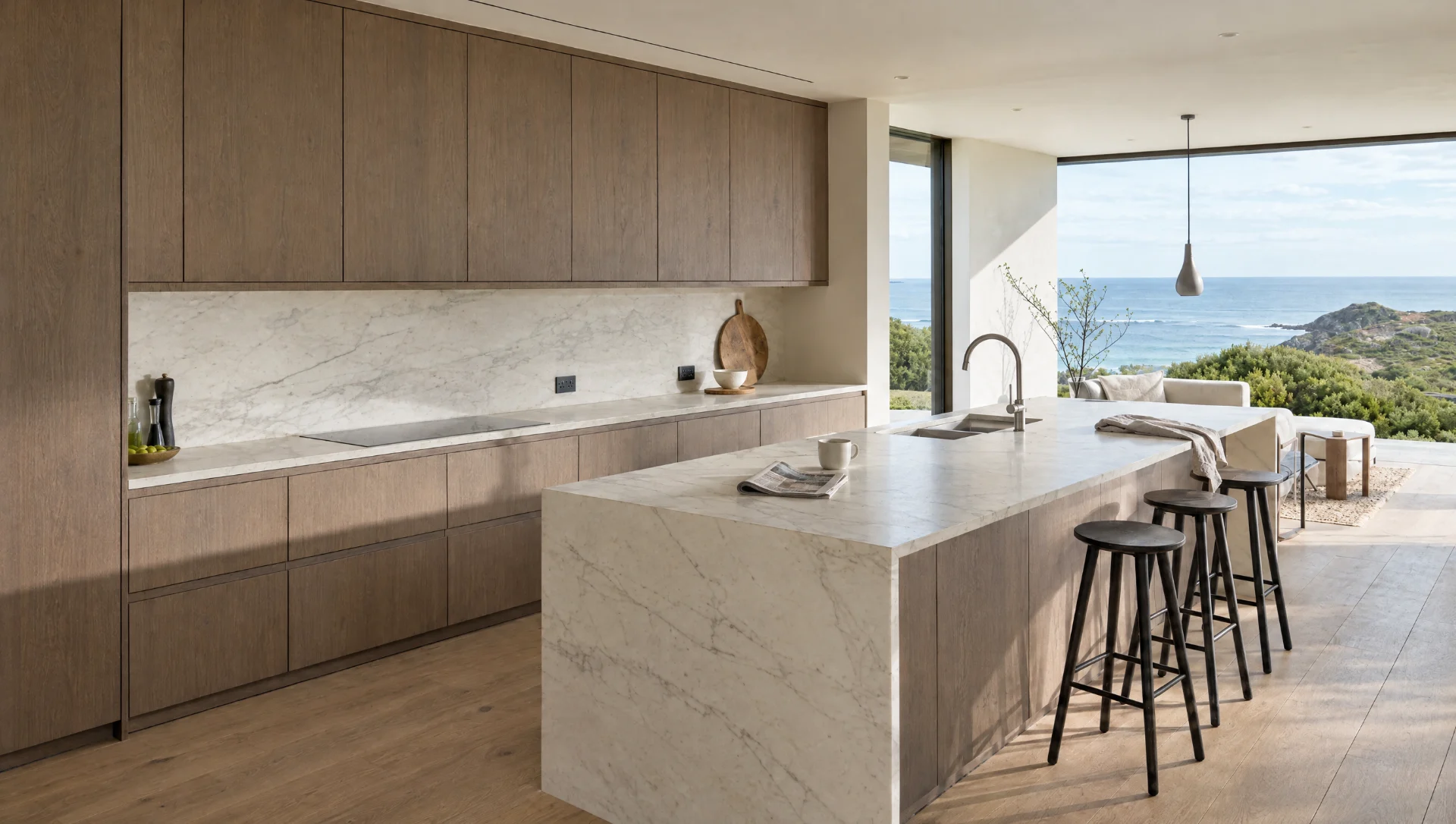 A flush handleless kitchen in a light, open room.
