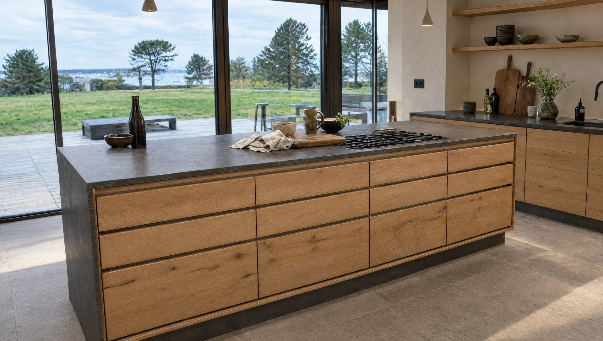 A handleless oak kitchen under low evening light.
